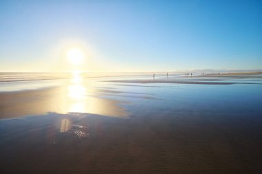 Güneş ile Atlantik Okyanusu 'nun batışı ve dalgalanan dalgalar Fonte da Telha plajının geniş kumlarında, Costa da Caparica, Portekiz