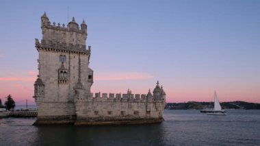 Belem Kulesi veya St Vincent Kulesi - Lisboa 'nın ünlü turizm merkezi - Tagus Nehri (Tejo) kıyısında alacakaranlıkta gün batımından sonra turist tekneleriyle birlikte. Lizbon, Portekiz