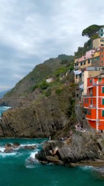 Cinque Terre Ulusal Parkı 'ndaki Riomaggiore köyündeki kayalıklardaki evler UNESCO Dünya Mirası Alanı, Liguria, İtalya. Kamera kaydıyla