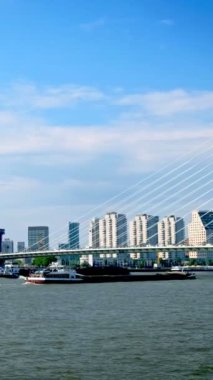 Rotterdam şehir manzarası ve Nieuwe Maas üzerindeki Erasmus köprüsü mavna kargo gemileriyle görünüyor. Rotterdam, Hollanda. Yatay kamera tavası