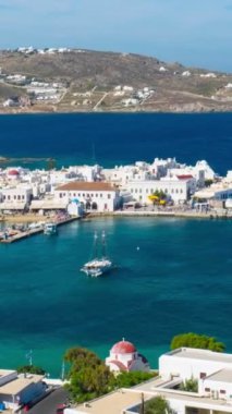 Meşhur yel değirmenleriyle Mykonos şehrinin zaman çizelgesi, tekneleri ve yolcu gemisiyle liman. Mykonos, Cyclades adaları, Yunanistan. Uzaklaştırma efekti