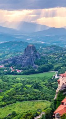 Yunanistan 'ın ünlü turizm beldesi Meteora' da, Rousanou manastırı ve St. Nicholas Anapavsa Manastırı 'nın üzerindeki güneş ışınlarıyla gün batımı zamanı. Kamera yansı hareketi