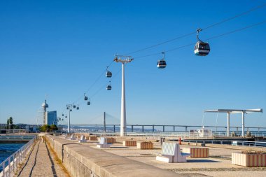 Telecabine Cable car in Lisbon in Parque des Nacoes Nations Park with Vasco da Gama bridge. Lisbon, Portugal clipart