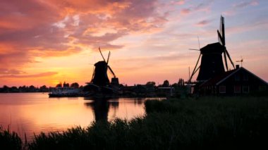 Hollanda 'nın ünlü turizm bölgesi Zaanse Schans' taki yel değirmenleri dramatik bir gökyüzü ile gün batımında. Zaandam, Hollanda