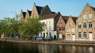 Belçika 'nın ünlü turist kasabası Bruges' de (Brugge) gün batımında eski evler ve kanallar. Kamera tavasıyla
