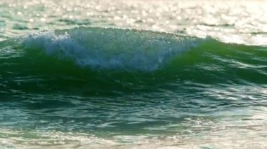 Gün batımında okyanus dalgalarını güneşe maruz bırakmak. Fonte da Telha, Costa da Caparica, Portekiz. Yavaş çekim