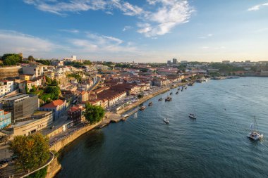 Vila Nova de Gaia şehri ve Douro nehrinin gün batımında turist botlarıyla manzarası. Porto, Portekiz