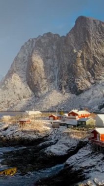 Kırmızı rorbu evleriyle ünlü ikonik geleneksel balıkçı köyü Hamnoy Lofoten Adaları, Norveç üzerinde. Kışın yağan kar ile. Yatay kaydırma