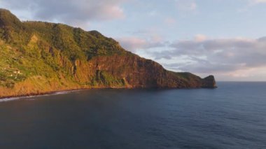 Madeira kayalıkları kıyı şeridi manzarası gündoğumunda, Guindaste bakış açısı, Madeira Adası, Portekiz. Dolly hareketine yaklaş.