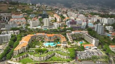 Funchal şehrinin havadan insansız hava aracı görüntüsü. Oteller, oteller ve Atlantik Okyanusu kıyısında yüzme havuzu. Funchal, Madeira, Portekiz. Geri çekilin. Doli atış.