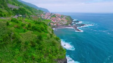 Portekiz 'in Madeira adasındaki Atlantik okyanus kıyısındaki Seixal köyünün insansız hava aracı görüntüsü. Dolly hareketine yaklaş.