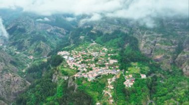 Portekiz 'in Madeira adası Miradouro da Eira do Serrado' dan Curral das Freiras köyünün insansız hava aracı görüntüsü. Yörünge paraşütü atışı