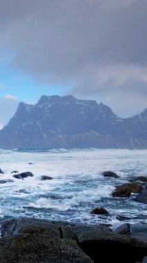 Norveç 'in fiyortlarında kışın karla kaplı kayalar. Utakliev plajı, Lofoten adaları, Norveç. Yatay kamera tavası
