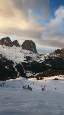 Gün batımında Dolomitler 'de kayak yapan insanlarla dolu bir kayak merkezinin zaman çizelgesi. Kayak alanı Belvedere. Canazei, İtalya