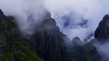 Hareket eden bulutlarla kaplı bir dağ. Pico de Arieiro yakınlarında, Madeira adası, Portekiz. Kamera tavası