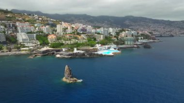Funchal şehrinin havadan insansız hava aracı görüntüsü. Oteller, oteller ve Atlantik Okyanusu kıyısında yüzme havuzu. Funchal, Madeira, Portekiz. Yörünge paraşütü atışı