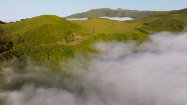 Manzaralı orman ve tepelerin bulutların üstündeki yolu gösteren drone görüntüleri. Madeira Adası, Portekiz. Dolly hareketini it.