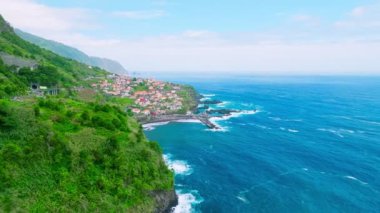 Portekiz 'in Madeira adasındaki Atlantik okyanus kıyısındaki Seixal köyünün insansız hava aracı görüntüsü. Dolly hareketine yaklaş.