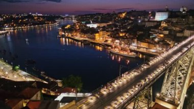 Aydınlatılmış Porto şehri ve Douro nehri ve Dom Luis köprüsünün manzarası turist bakış açısıyla Miradouro da Serra do Pilar 'dan akşam tramvayla alacakaranlıkta. Porto, Vila Nova de Gaia, Portekiz. Kamera tavası