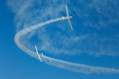 Dublör akrobatik uçak dumanla mavi gökyüzünde gösteri yapıyor. Takım çalışması, işbirliği, koordinasyon, güven, hassasiyet, zorluk, zorluk, hız, sinerji kavramı