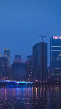 Guangzhou 'nun Zhujiang İnci Nehri üzerindeki Liede Köprüsü manzarası ve geceleri aydınlanan finansal bölgenin modern gökdelenleri. Guangzhou, Çin. Yatay kamera tavası