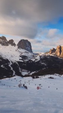 Gün batımında Dolomitler 'de kayak yapan insanlarla dolu bir kayak merkezinin zaman çizelgesi. Kayak alanı Belvedere. Canazei, İtalya. Yatay kamera tavası