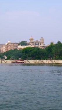 Pichola gölündeki hareket halindeki tekneden Udaipur Şehir Sarayı manzarası. Lüks saray Rajput mimarisi Rajasthan 'ın Mewar Hanedanı hükümdarları ve Hindistan' ın ünlü turist simgesidir. İnanılmaz Hindistan mirası..