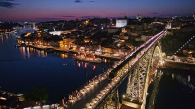 Porto şehri ve Douro nehri manzarası ve Dom Luis köprüsü ünlü turist bakış açısı Miradouro da Serra do Pilar 'dan metro tramvayı ile akşam alacakaranlığı. Porto, Vila Nova de Gaia, Portekiz
