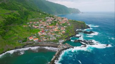 Portekiz 'in Madeira adasındaki Atlantik okyanus kıyısındaki Seixal köyünün insansız hava aracı görüntüsü. Yörünge parallax eğim atışı