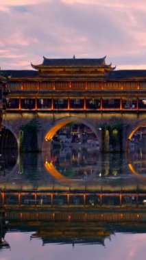 Çin turizm merkezi Feng Huang Antik Şehir Anka Kasabası Tuo Jiang Nehri üzerinde gece aydınlatılmış köprü. Hunan Eyaleti, Çin. Kamera tavası