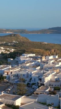 Geleneksel Yunan kilisesi ve okyanus kıyısına sahip Plaka köyünün panoramik manzarası. Milos Adası, Yunanistan. Kamera tavası