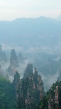 Çin - Zhangjiajie taş ünlü turistik uçurum Dağları sis bulutları Wulingyuan, Hunan, Çin, sütun. Kamera pan ile