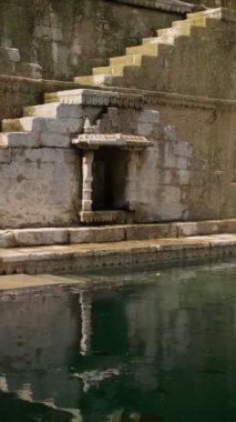 Toorji Ka Jhalra Baoli Stepwell 'deki su deposu. Jodhpur, Rajasthan, Hindistan' daki su kaynaklarından biri. Güneşli bir gün, su tabancaları havuzun duvarlarını yansıtıyor. Kamera yatay tavası