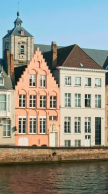 Belçika 'nın ünlü turist kasabası Bruges Brugge' de gün batımında eski evler ve kanallar. Sokaktan geçen bir araba.