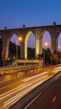 Campolide İstasyonu yakınlarındaki otoyol trafiğinin zaman aşımına uğraması ve arka planda Aguas Livres Aqueduct ile birlikte gece araba ışıkları izleri. Lizbon, Portekiz. Kamera tavası