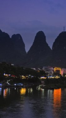 Yangshuo şehrinin manzarası Li nehrinin arka planında dramatik karst dağ manzarasıyla aydınlandı. Yangshuo, Çin. Yatay kamera tavası