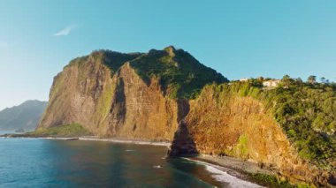 Madeira kayalıkları kıyı şeridi manzarası gündoğumunda, Guindaste bakış açısı, Madeira Adası, Portekiz. Yörünge paraşütü atışı