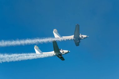 Dublör akrobatik uçak dumanla mavi gökyüzünde gösteri yapıyor. Takım çalışması, işbirliği, koordinasyon, güven, hassasiyet, zorluk, zorluk, hız, sinerji kavramı