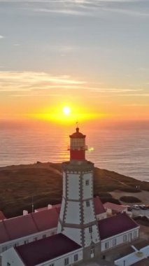 Atlantik Okyanusu 'ndaki Cabo Espichel Burnu' ndaki deniz fenerinin günbatımında görüntüsü. Sesimbra, Portekiz. Yaya yatağı yatay atış