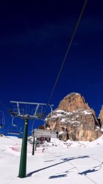 Kablolu sandalyede kayak kaldırmanın birinci şahıs bakış açısı FPV 'nin hızlı ileri etkisi alp kayağı için yükselir. Dolomitler 'de kayak yapan insanlarla kayak pisti. Kayak alanı Belvedere. Canazei, İtalya