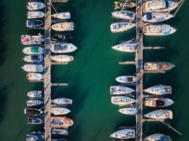 Yatı olan Marina, yukarıdan aşağıya doğru insansız hava aracı. Rıhtıma demirlemiş tekne ve yatlar. Cascais, Portekiz gün batımında