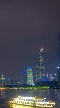 Guangzhou şehri, Pearl Nehri üzerindeki Kanton Kulesi 'nin ufuk çizgisi, akşam panoramasında suda turist tekneleriyle aydınlandı. Guangzhou, Çin