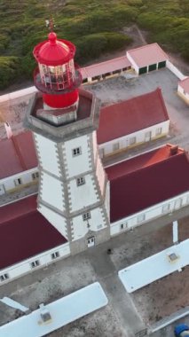 Cabo Espichel Cape Espichel 'deki deniz fenerinin hava aracı görüntüsü Atlantik Okyanusu' nda gün batımında. Sesimbra, Portekiz. Eğik atış