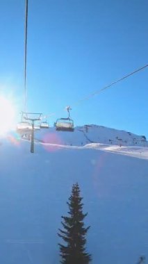 Kablolu sandalyede kayak kaldırmanın birinci şahıs bakış açısı FPV 'nin hızlı ileri etkisi alp kayağı için yükselir. Dolomitler 'de kayak yapan insanlarla kayak pisti. Kayak alanı Belvedere. Canazei, İtalya