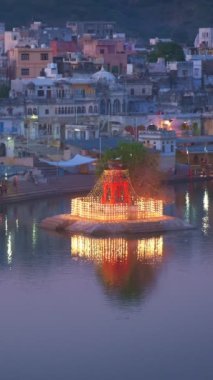 Hindistanın ünlü Hinduizm hac kasabası kutsal Hindu dini şehri Puşkar Brahma tapınağı, aarti töreni, göl ve gün batımında aydınlanan ghat manzarası. Rajasthan, Hindistan.