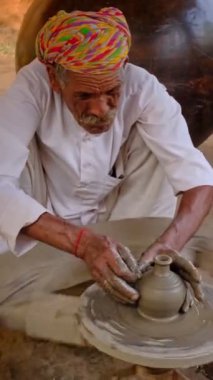 Hintli çömlekçi: çömlekçi çarkını fırlatmak ve seramik kap ve kil kapları şekillendirmek: çömlek atölyesinde kap, kavanoz. Tecrübeli usta. Shilpagram, Udaipur, Rajasthan, Hindistan 'dan el işi.