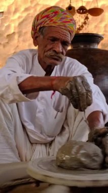 Hintli çömlekçi: çömlekçi çarkını fırlatmak ve seramik kap ve kil kapları şekillendirmek: çömlek atölyesinde kap, kavanoz. Tecrübeli usta. Shilpagram, Udaipur, Rajasthan, Hindistan 'dan el işi.
