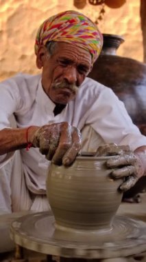 Hintli çömlekçi: çömlekçi çarkını fırlatmak ve seramik kap ve kil kapları şekillendirmek: çömlek atölyesinde kap, kavanoz. Tecrübeli usta. Shilpagram, Udaipur, Rajasthan, Hindistan 'dan el işi.