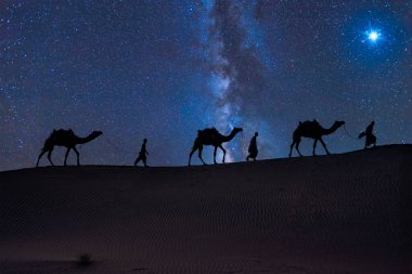 Noel İsa 'nın doğum konsepti - Magi' ye Tapma, Üç Bilge Adam, Üç Kral, ve deve siluetleriyle çölün kum tepelerinde gezinen üç İncil büyücüsü Bethlehem yıldızını takip eder