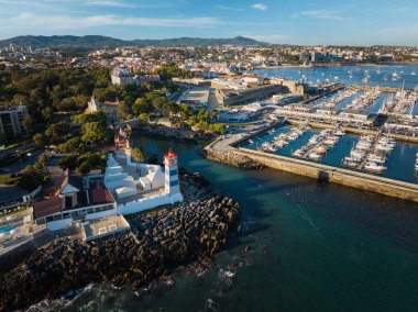 Santa Marta deniz feneri ve Cascais marinasının hava manzarası Cascais şehir manzaralı demirli yat tekneleri, gün batımında Portekiz